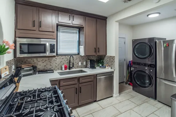 a kitchen with a sink a stove top oven and cabinets