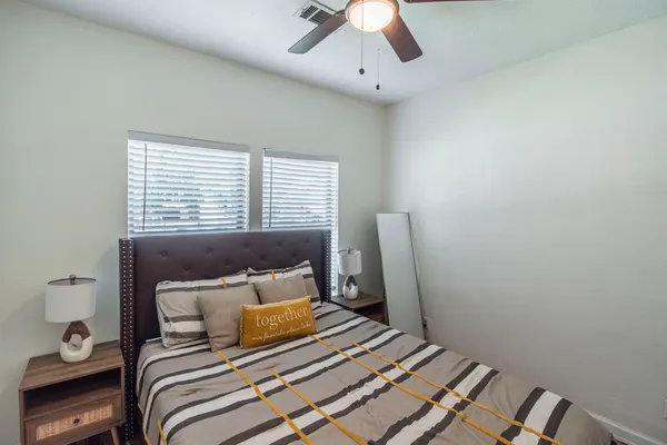 a bedroom with a bed and wooden floor