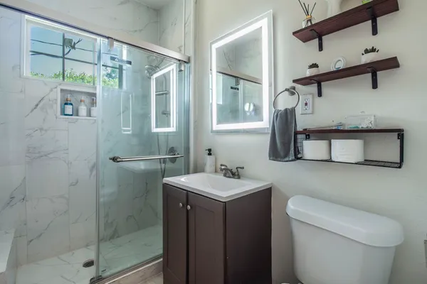 a bathroom with a sink a toilet and shower