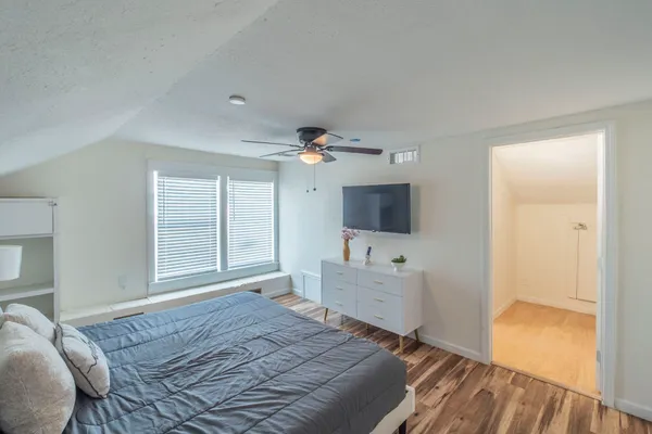 a spacious bedroom with a bed and a flat screen tv