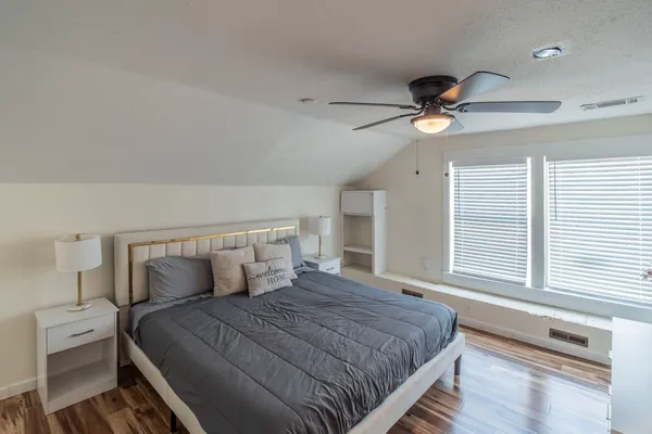 a bedroom with a large bed and a chandelier