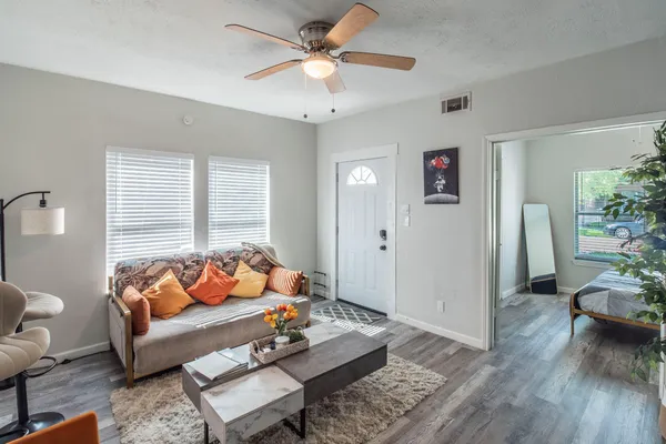 a living room with furniture and wooden floor