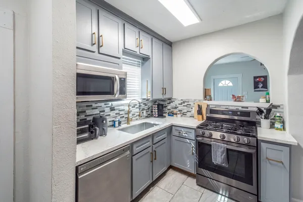 a kitchen with cabinets stainless steel appliances and a sink
