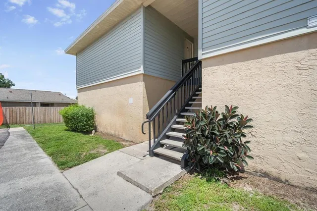 a view of backyard with plants and wooden fence