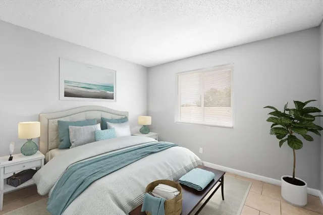 a bedroom with a bed and a potted plant