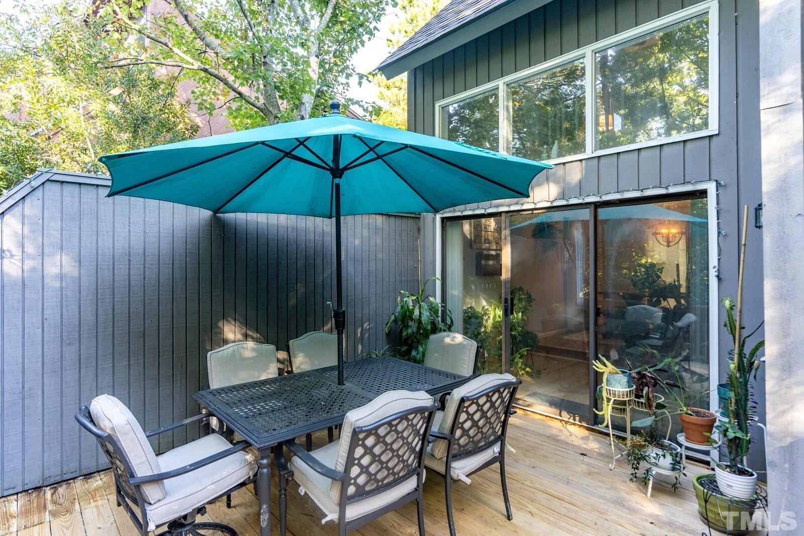 4353 Sunscape Lane Raleigh, NC 27613 - Photo 27 of 30 a patio table and chairs under an umbrella