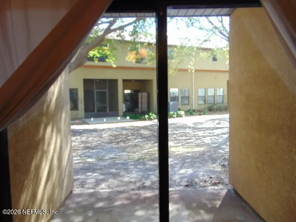 a view of a room with a large window and front door
