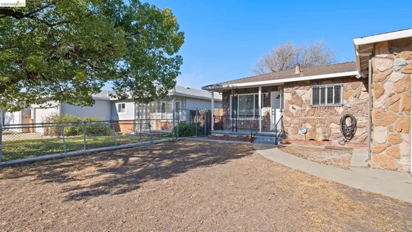 a front view of a house with a yard and glass top table and chairs