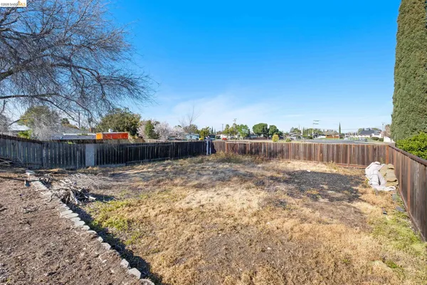 a view of a yard with wooden fence