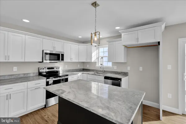 a kitchen with kitchen island a sink counter top space appliances and cabinets
