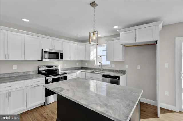 a kitchen with kitchen island a sink counter top space appliances and cabinets