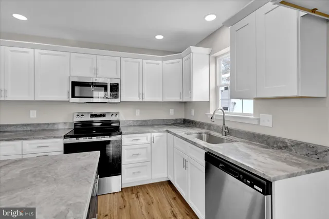 a kitchen with a sink stove top oven and cabinets