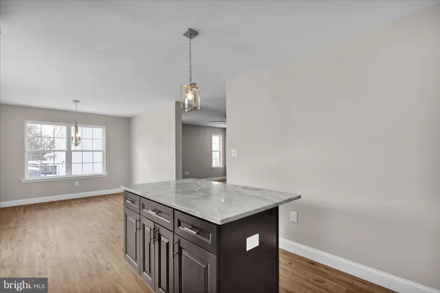 an empty room with wooden floor and window