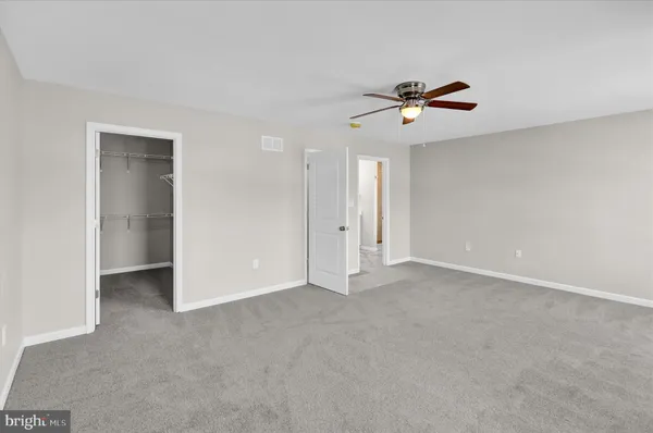 an empty room with closet and windows