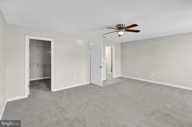 an empty room with closet and windows