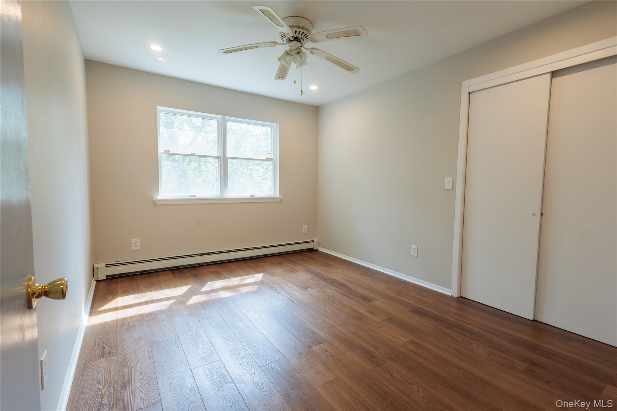 14 Hill Road St. James, NY 11780 - Photo 20 of 29 an empty room with wooden floor fan and windows