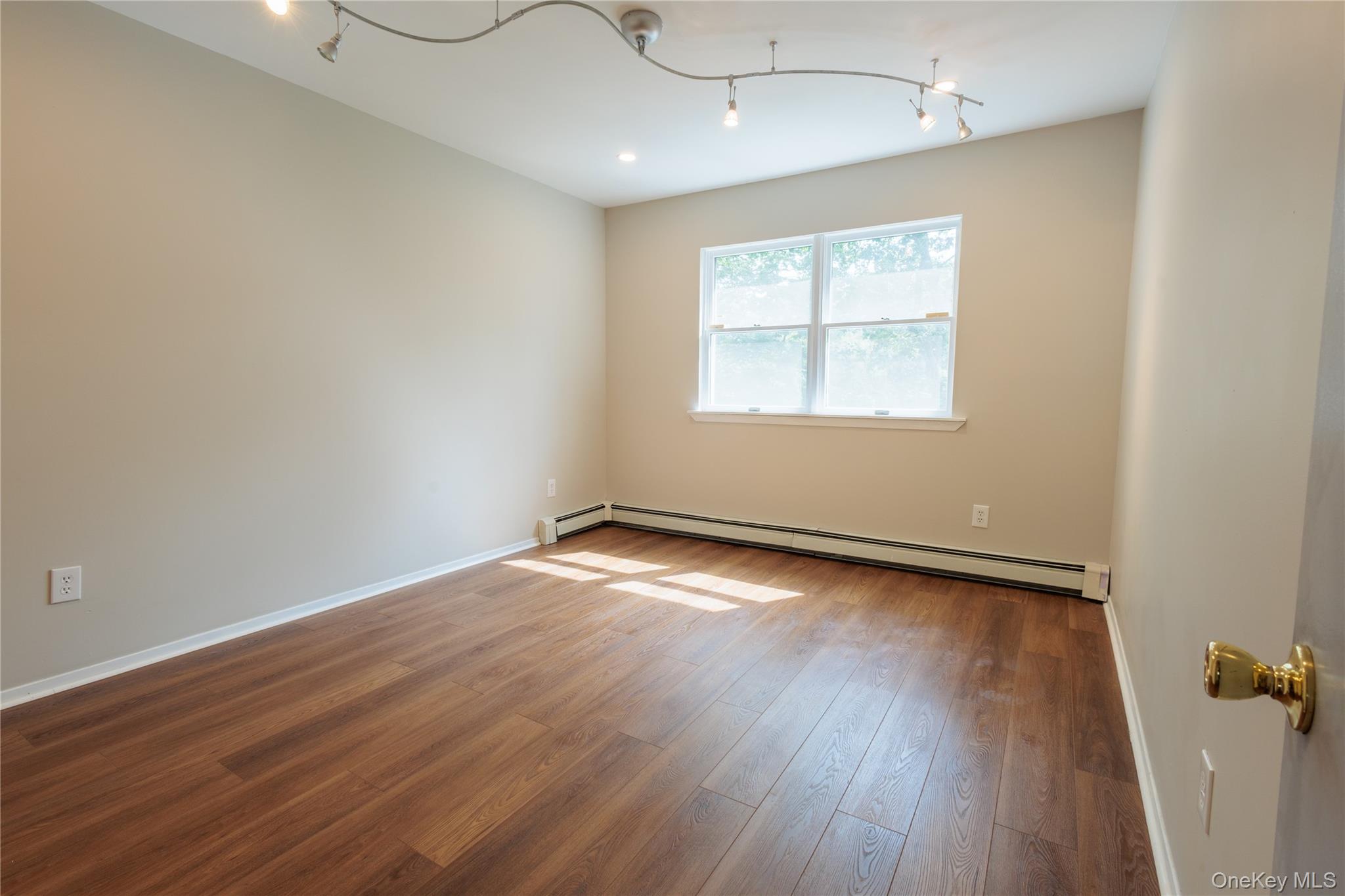 14 Hill Road St. James, NY 11780 - Photo 22 of 29 an empty room with wooden floor and windows