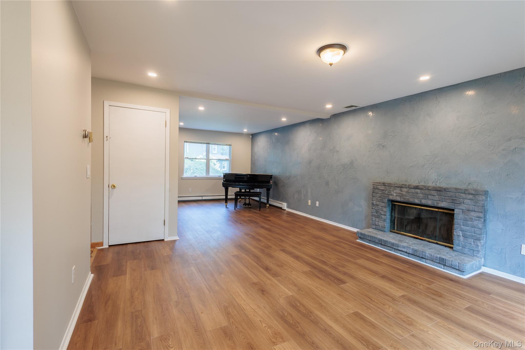 14 Hill Road St. James, NY 11780 - Photo 4 of 29 a view of a livingroom with wooden floor and a fireplace