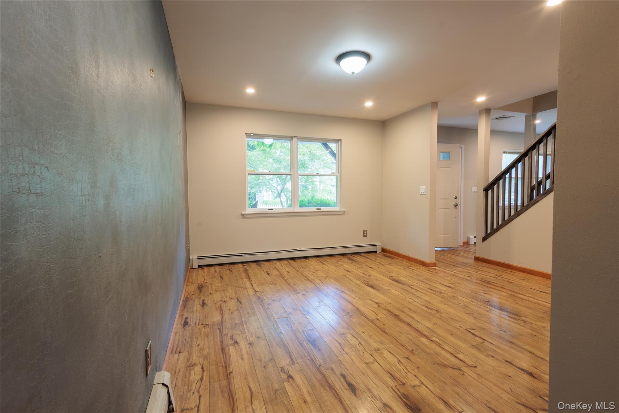 14 Hill Road St. James, NY 11780 - Photo 9 of 29 an empty room with wooden floor and windows