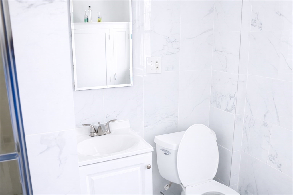 144 Washington Street Springfield, MA 01108 - Photo 15 of 18 a bathroom with a toilet sink and mirror