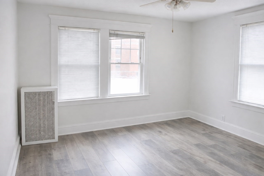 144 Washington Street Springfield, MA 01108 - Photo 10 of 18 an empty room with wooden floor and windows
