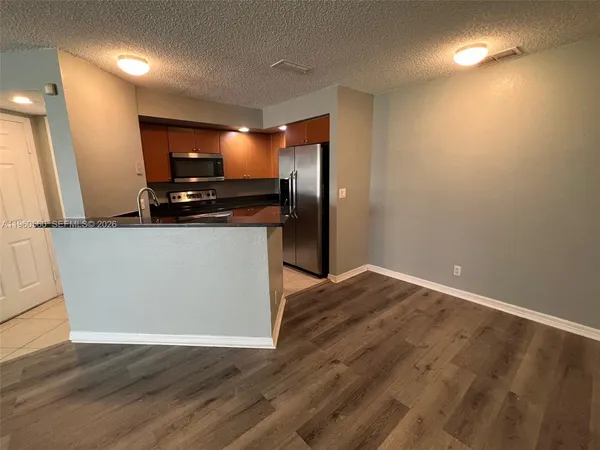 a kitchen with granite countertop a refrigerator and a stove