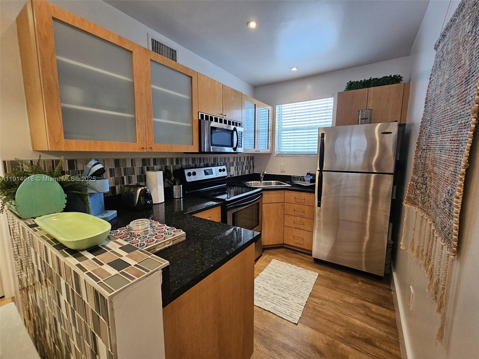 751 Collins Avenue, Unit 3 Miami Beach, FL 33139 - Photo 20 of 35 a kitchen with a refrigerator and a stove top oven