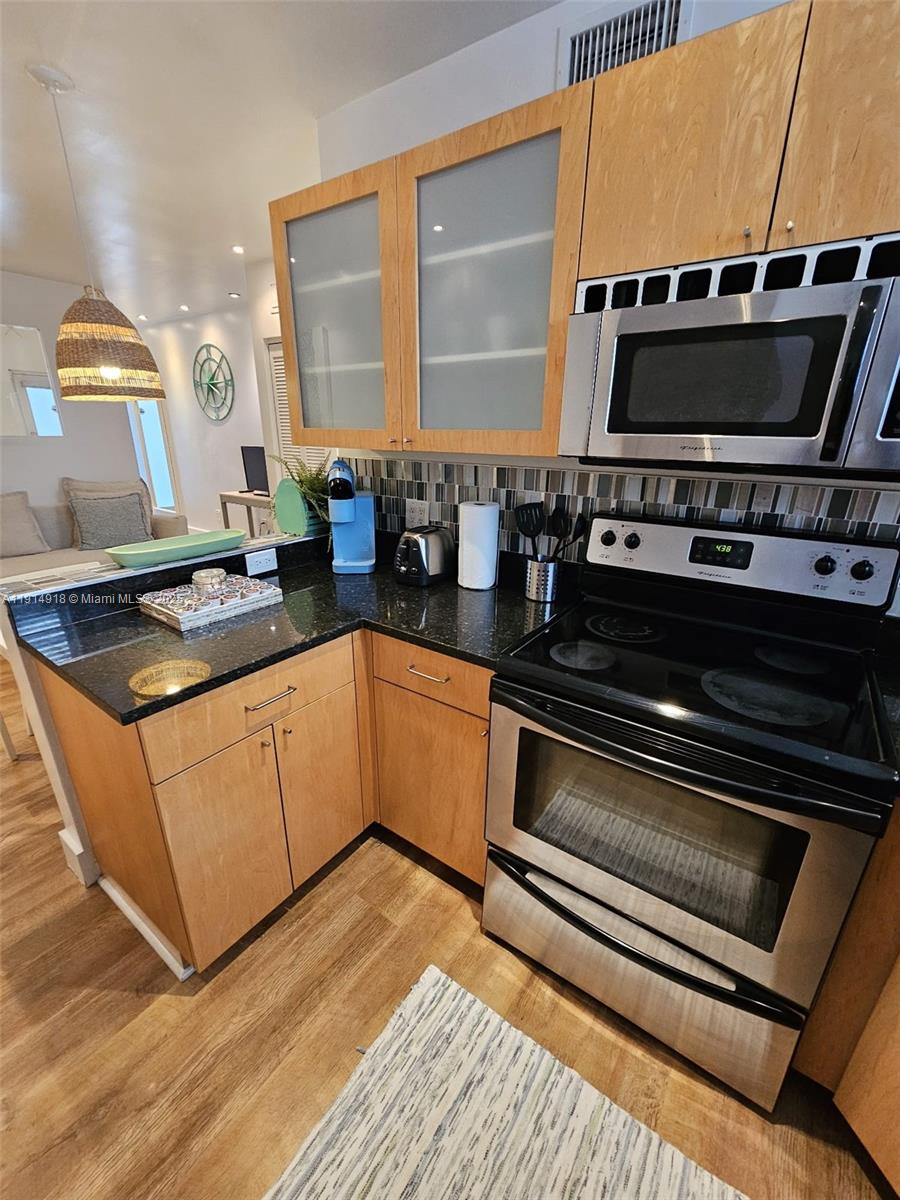 751 Collins Avenue, Unit 3 Miami Beach, FL 33139 - Photo 26 of 35 a kitchen with stainless steel appliances a stove and a microwave