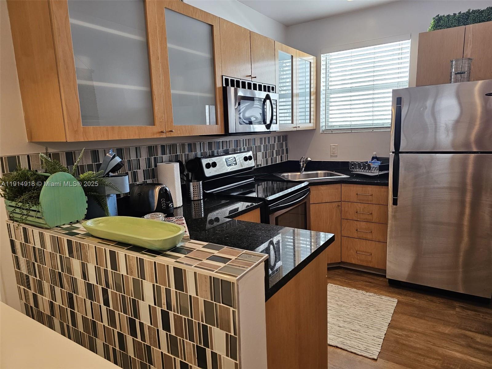 751 Collins Avenue, Unit 3 Miami Beach, FL 33139 - Photo 27 of 35 a kitchen with stainless steel appliances granite countertop a sink stove and refrigerator