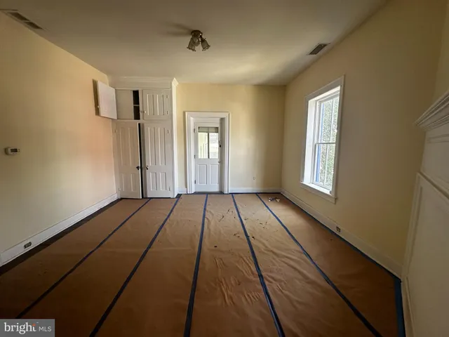 a view of a room with wooden floor closet and windows