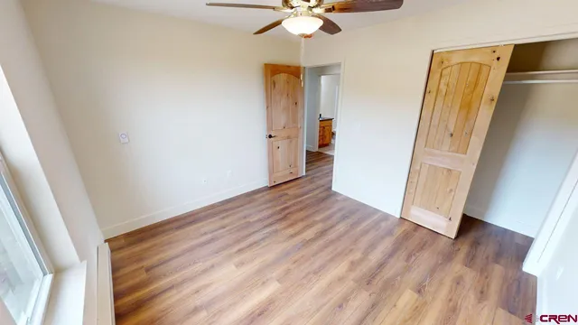 an empty room with wooden floor and entryway