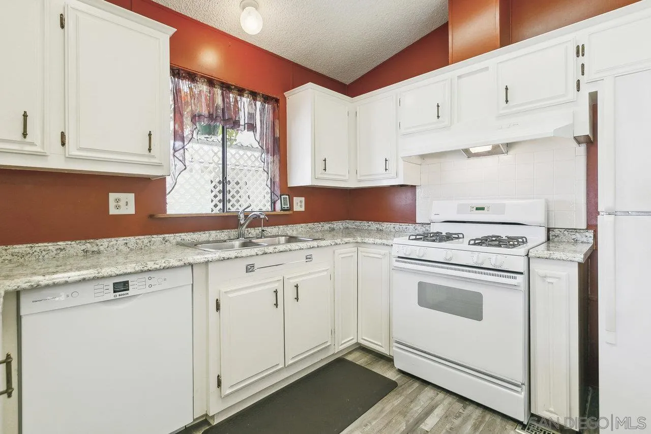11949 Riverside Drive, Unit SPC 8 Lakeside, CA 92040 - Photo 5 of 29 a kitchen with granite countertop white cabinets and white appliances