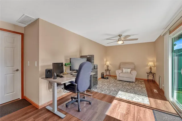 a view of a workspace with furniture and wooden floor
