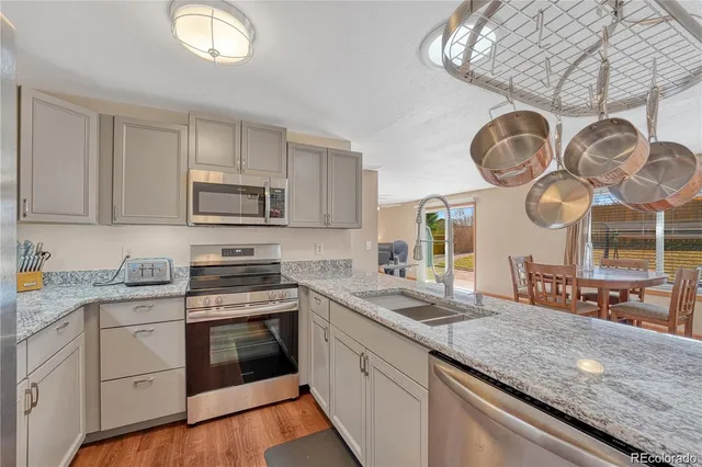 a kitchen with kitchen island granite countertop a sink a stove and cabinets