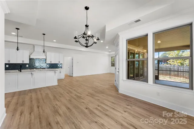 a large kitchen with stainless steel appliances granite countertop a oven a stove and a wooden floors