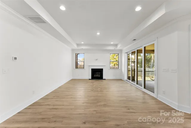 a view of an empty room with a window and fireplace