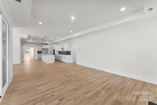 a view of kitchen with kitchen island wooden floor center island and stainless steel appliances