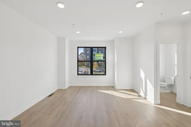 an empty room with wooden floor and a window
