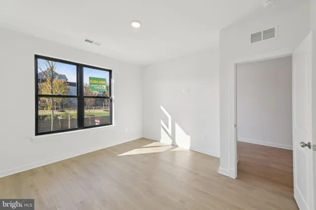 an empty room with wooden floor and windows