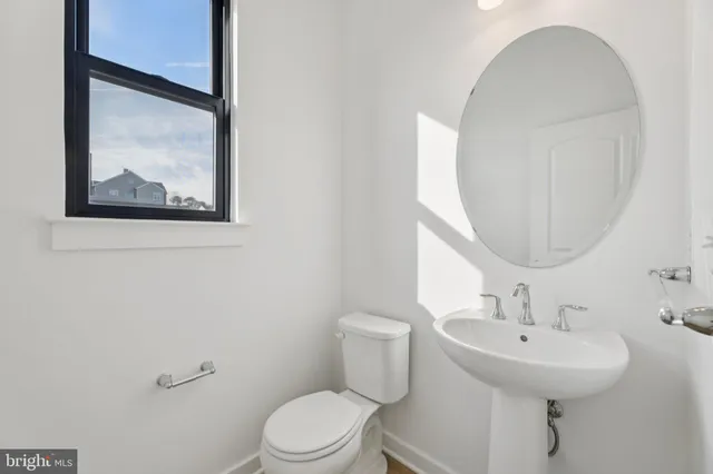 a bathroom with a toilet a sink and mirror
