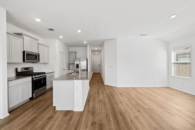 a view of a kitchen with wooden floor and electronic appliances