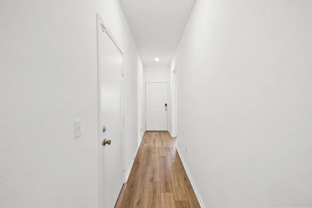 a view of a hallway with wooden floor