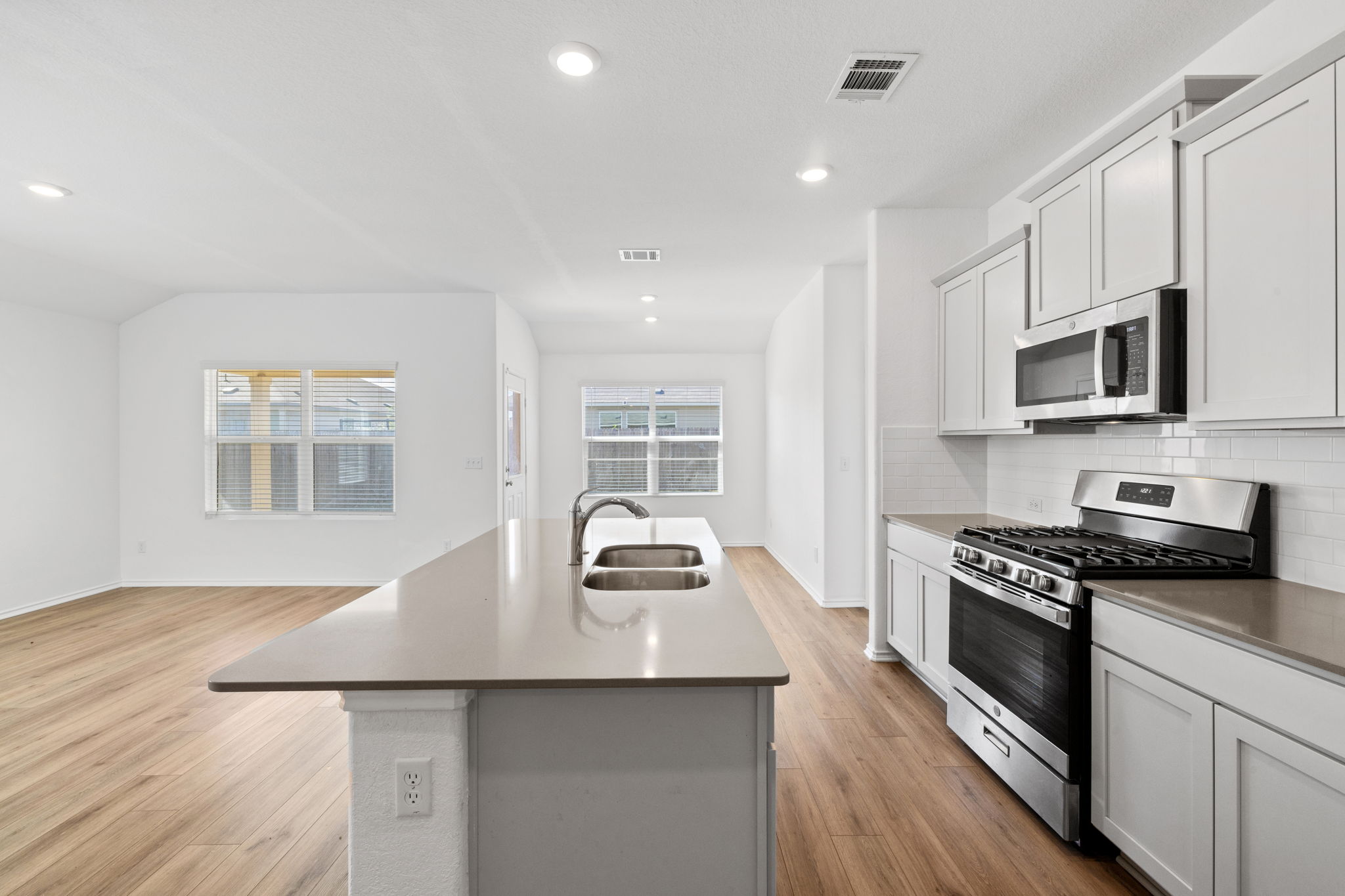 110 Madrid Kyle, TX 78640 - Photo 3 of 29 a kitchen with stainless steel appliances a stove sink microwave and cabinets