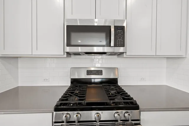 a stove top oven sitting inside of a kitchen