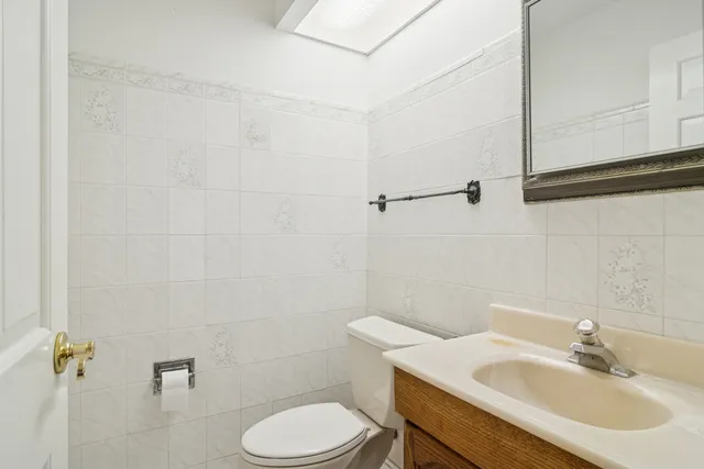 a bathroom with a sink a toilet and a mirror