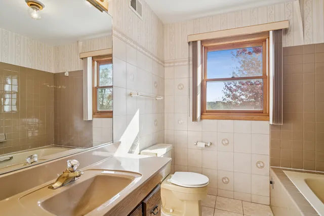 a bathroom with a sink and mirror with toilet