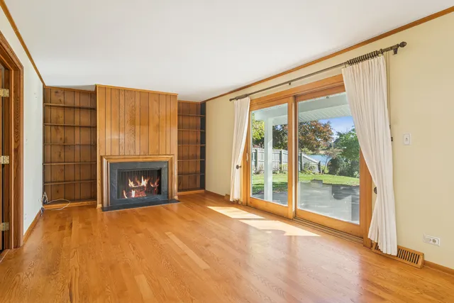 a view of an empty room with a fireplace and a window