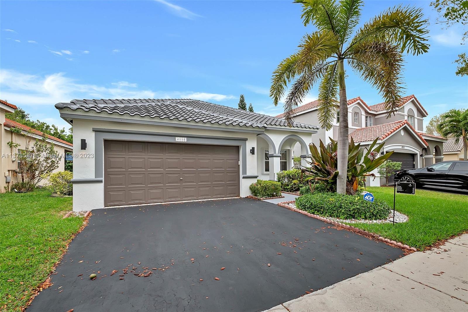 a front view of a house with a garden and mountain