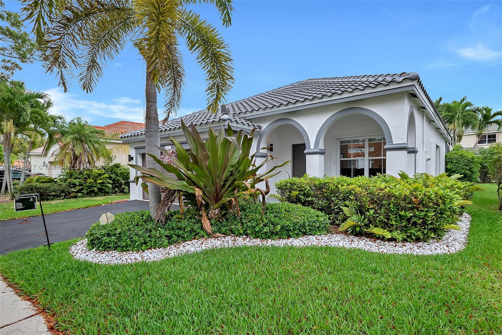 4115 Sabal Ridge Circle Weston, FL 33331 - Photo 12 of 31 a front view of a house with a garden