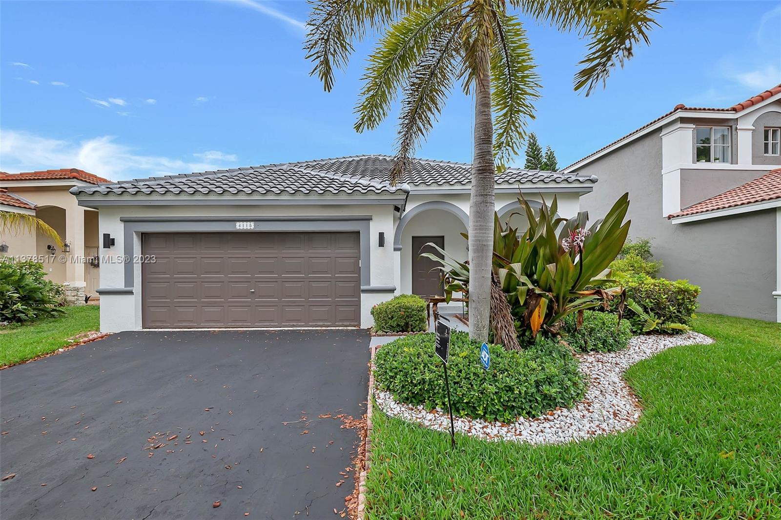 4115 Sabal Ridge Circle Weston, FL 33331 - Photo 2 of 31 a front view of a house with a garden